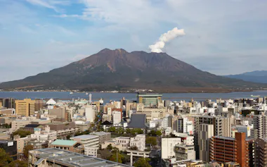 桜島は標高1117メートル。市街地からは錦江湾を挟んで最短約4キロメートルの場所にある。これほど活発な火山が人口約60万人の都市に近接するのは世界でも珍しい(鹿児島市)