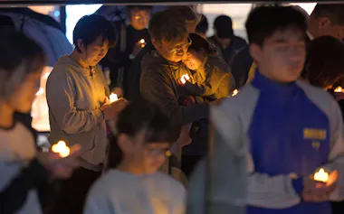 熊本地震の前震の発生時刻に黙とうする人たち(14日午後9時26分、熊本県益城町)