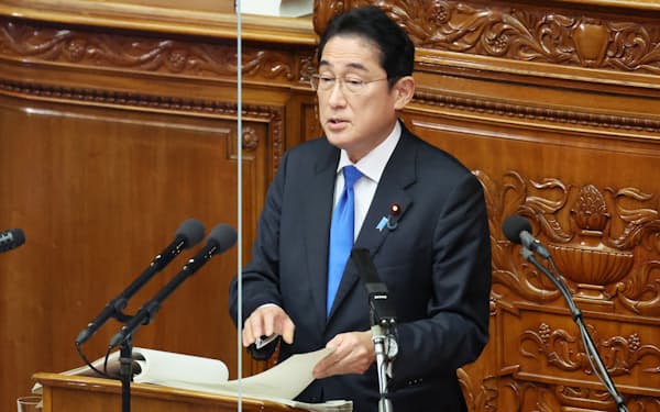 アクリルボードが設置された衆院本会議場の演壇でマスクを外して施政方針演説をする岸田首相(23日)