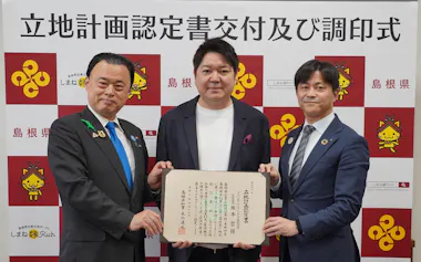 立地計画認定書を交付した丸山達也・島根県知事㊧と坂本哲・アクシスITパートナーズ社長㊥(17日、松江市)