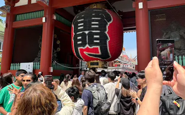 浅草寺の雷門にスマホをかざす観光客ら(東京都台東区)