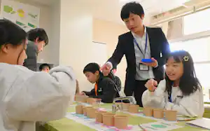 金融のゲームで遊ぶ小学生らと、福岡銀行の行員(右から2人目)=1月、福岡市 金融のゲームで遊ぶ小学生らと、福岡銀行の行員(右から2人目)=1月、福岡市