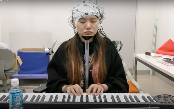 電子ピアノを演奏したときの脳波を測定する様子＝お茶の水女子大学提供
