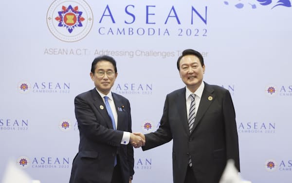 カンボジアで開かれた日韓首脳会談で握手する岸田首相（左）と韓国の尹錫悦大統領＝共同