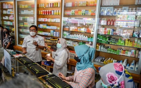 薬局でのせき止めシロップの販売状況を調べるインドネシア保健当局の職員（2022年10月）＝アンタラ通信・ロイター