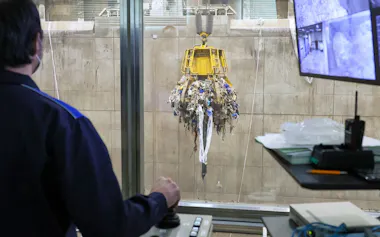 巨大アームを操作して廃棄物をつかむ(写真=木寺 良三)