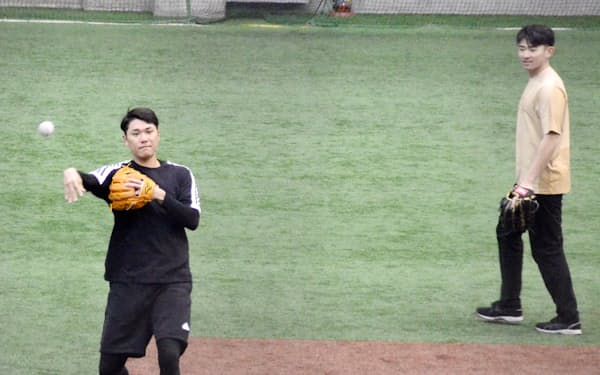 自主練習でノックを受ける巨人・坂本（左）と新人の萩尾（30日、川崎市のジャイアンツ球場）＝共同