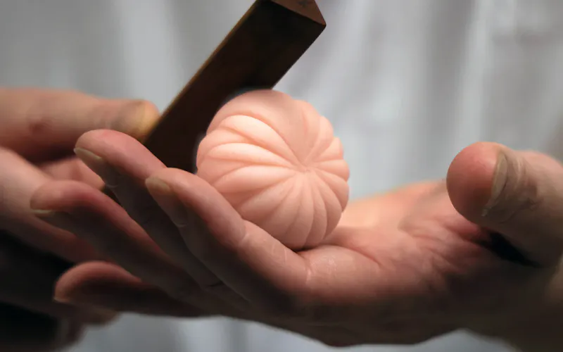 三角ベラを使い菊の花弁を作っていく。シンプルなデザインだからこそ、見る人は様々な想像を広げる(京都市の塩芳軒) 三角ベラを使い菊の花弁を作っていく。シンプルなデザインだからこそ、見る人は様々な想像を広げる(京都市の塩芳軒)