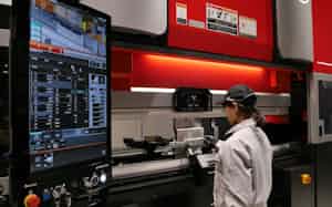 作業員はモニターを見ながら精密に板金を加工できる(写真は次世代機のデモ風景) 作業員はモニターを見ながら精密に板金を加工できる(写真は次世代機のデモ風景)