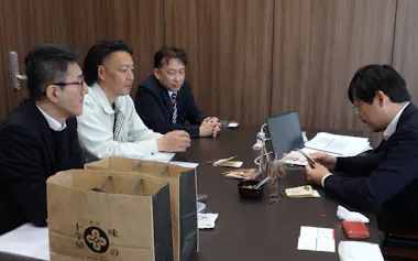 五味商店のバイヤー㊨が石川県内の食品企業に商品の特徴などを聞いた(24日、金沢市)