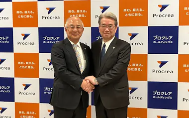 握手する成田氏㊧と石川氏(24日、青森市)