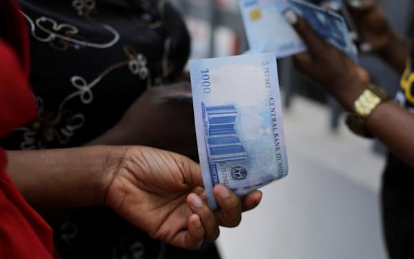 ナイジェリアの新紙幣を手にする人＝ロイター