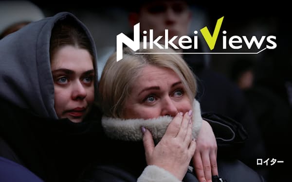 ロシアのミサイル攻撃で破壊された集合住宅を見つめるウクライナの女性たち（１月１５日、ウクライナ東部ドニプロ）＝ロイター