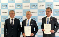 合併認可書を手にする福井銀行の長谷川英一頭取㊥と福邦銀行の湯浅徹頭取㊨(27日、金沢市)