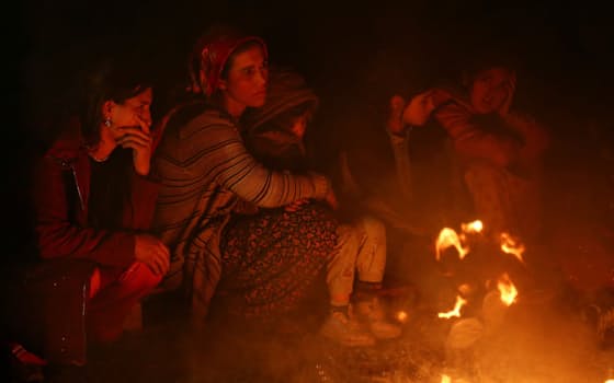 夜になり、たき火に当たる被災者ら（6日、トルコ南部カフラマンマラシュ）=ロイター