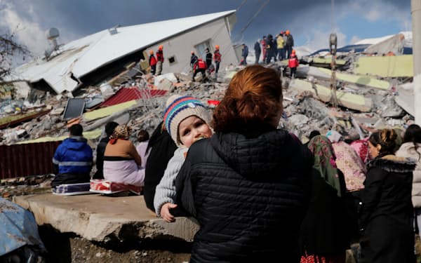 大地震後、がれきの前でたたずむ市民（7日、トルコ南部ガジアンテプ）＝ロイター