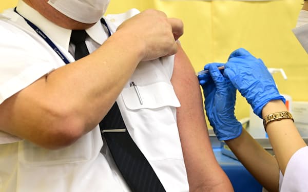 新型コロナウイルスのオミクロン型に対応したワクチンの職場接種を受けるANAの社員（17日、羽田空港）