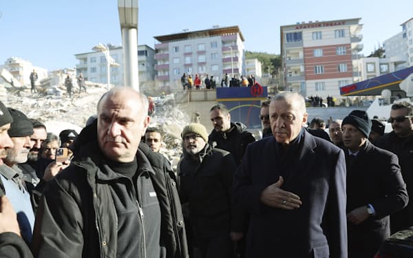 トルコのエルドアン大統領（右）は地震の発生後に初めて被災地を訪れた（8日、南部カフラマンマラシュ）＝トルコ大統領府提供・AP