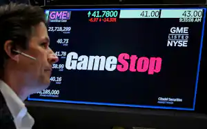 ゲームストップの取引情報とニューヨーク証券取引所のトレーダー(写真は2024年5月)=ロイター ゲームストップの取引情報とニューヨーク証券取引所のトレーダー(写真は2024年5月)=ロイター