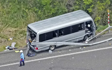 福島県郡山市の磐越自動車道でガードレールに衝突したマイクロバス(6日午後0時18分)=共同通信社ヘリから