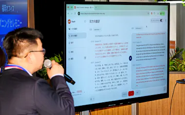 ベトナムのソタテックは福岡で100人規模の拠点を計画する(開所式で自社のAI翻訳アプリを使う場面)=3月、福岡市
