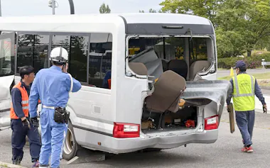 事故現場から移動されたマイクロバスを確認する警察官(6日午後、福島県郡山市)=共同