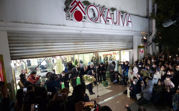 岡島百貨店は多くの買い物客が見守るなか、現店舗での営業最終日のシャッターを下ろした（14日、甲府市）