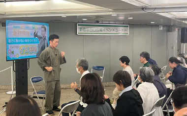 「暑熱順化スタート講座」で簡単な体操を教える簗瀬さん(9日、東京都新宿区)