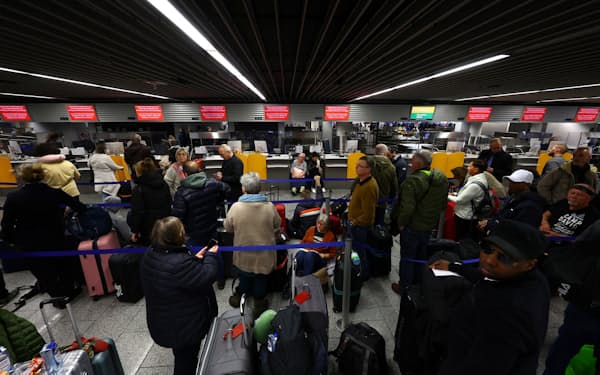 システム障害で欠航・遅延が発生し、ルフトハンザ航空の窓口に乗客が列をなした（15日、フランクフルト空港）=ロイター