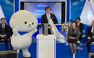 水素吸蔵合金タンクを披露する赤坂熱供給の高木盛正社長(12日、東京都港区)