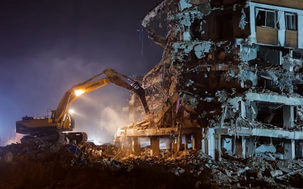 被害を受けた建物を取り壊す建設車両（19 日、ハタイ県）＝ロイター