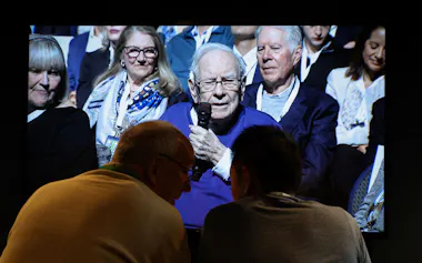 Shareholders watch a screen as Warren Buffett addresses the Berkshire Hathaway Inc's annual shareholders meeting, the conglomerate's first since he stepped down after 60 years as chief executive and was succeeded by Greg Abel, in Omaha, Nebraska, U.S., May 2, 2026. REUTERS/Brendan McDermid