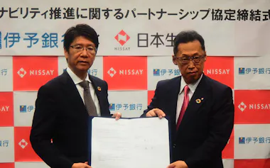 伊予銀の栗田営業副本部長㊧と日本生命の塙専務執行役員(15日、松山市)