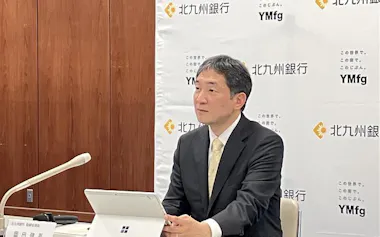 スマホ完結型支店開設を発表する北九州銀の岡田頭取(15日、北九州市)