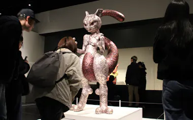 吉田泰一郎氏の作品「ミュウツー」に見入る入場者ら(9日、札幌市)