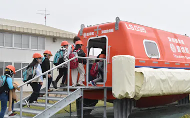 避難訓練で津波救命艇に乗り込む地元小学生(15日、北海道豊頃町)