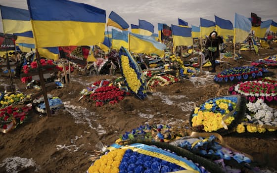 【2月24日(366日目)】バフムトで亡くなったウクライナ兵の夫の墓を探す女性（ハリコフ）=AP