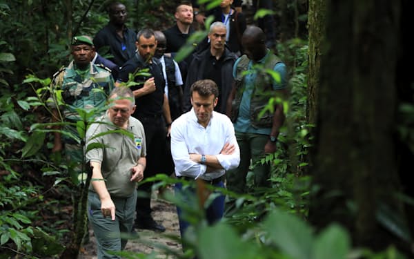 ２日、ガボンの首都リーブルビル近郊の森林を訪れたマクロン大統領㊨＝AP