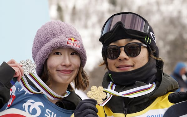 スノーボード世界選手権の男子ビッグエアを制し、日本勢初となる金メダルを獲得した長谷川帝勝。左は女子で2位となった鬼塚雅（4日、バクリアニ）＝共同