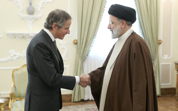 イランのライシ大統領（右）と握手するグロッシ事務局長（４日、テヘラン）＝WANA・ロイター