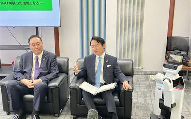 井上首相補佐官㊧と歓談する北九州市の武内市長(25日、北九州市役所)