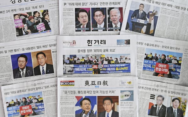 韓国政府が元徴用工訴訟問題の解決策を発表したことを大きく取り上げた7日付の韓国紙＝共同