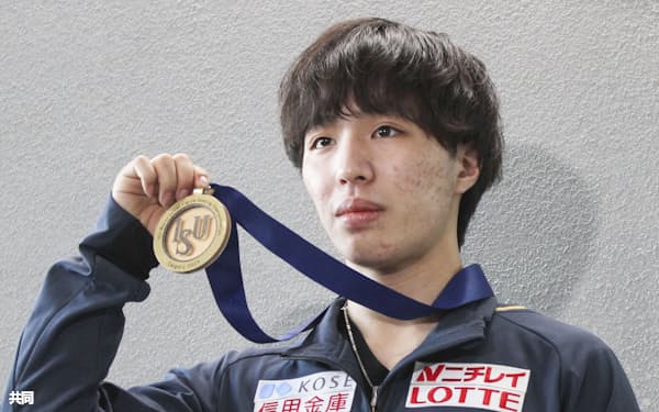 フィギュアスケートの世界ジュニア選手権から帰国しメダルを掲げる、男子を制した三浦佳生(7日、成田空港)=共同