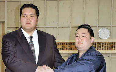 師匠の伊勢ケ浜親方㊧と握手する新十両の嵐富士(27日、東京都墨田区の伊勢ケ浜部屋)=共同