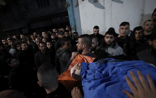 ７日、ジェニンの難民キャンプに対するイスラエル軍の急襲作戦での死者を運ぶパレスチナ人ら＝ＡＰ