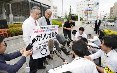 「1票の格差」訴訟の判決を受け、広島高裁岡山支部前で取材に応じる原告側の升永英俊弁護士(奥左)ら(28日午後)=共同