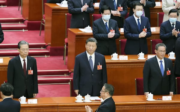 12日、北京の人民大会堂で中国全人代の全体会議に臨む習近平国家主席（中央）と李強首相（右）＝共同