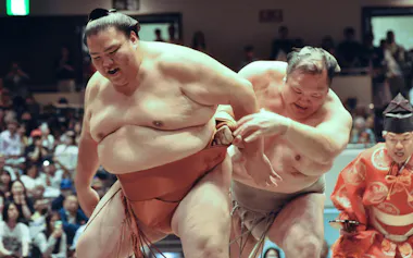 御嶽海㊧と最後の一番を取った元小結北勝富士の大山親方(30日、両国国技館)=共同