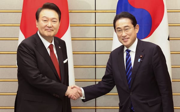 会談を前に韓国の尹錫悦大統領㊧と握手する岸田首相（16日、首相官邸）