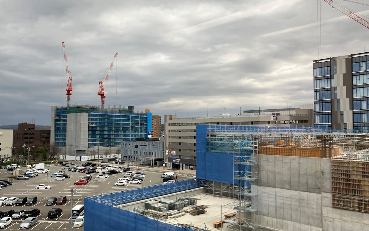 金沢駅西側で建設中の大規模マンション（左）。日銀金沢支店の新しい建物（手前）も工事中だ